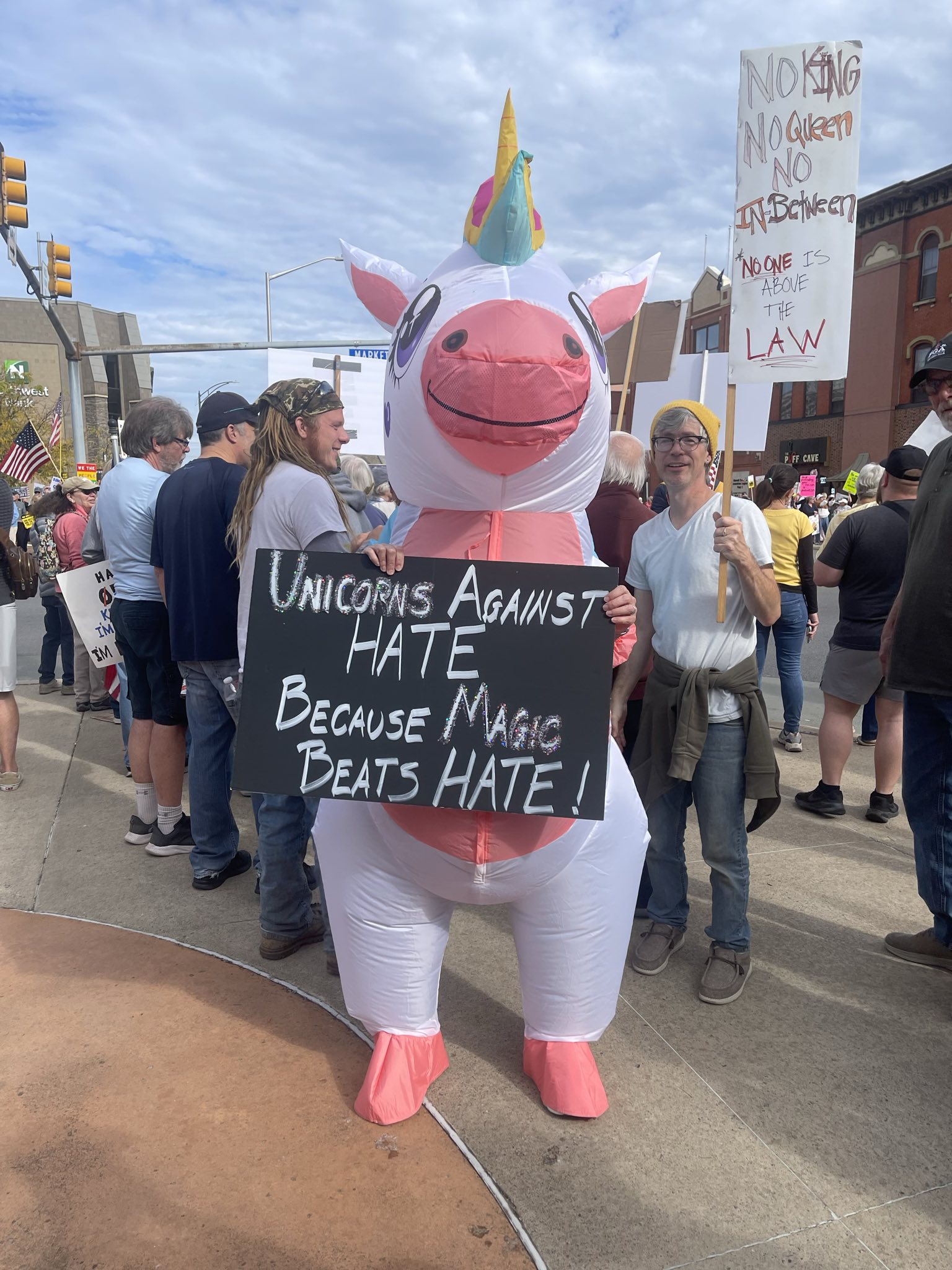 A protester dressed as an inflatable Unicorn at No Kings 2.0 in Williamsport carries a sign that says Unicorns Against Hate because Magic Beats HATE!